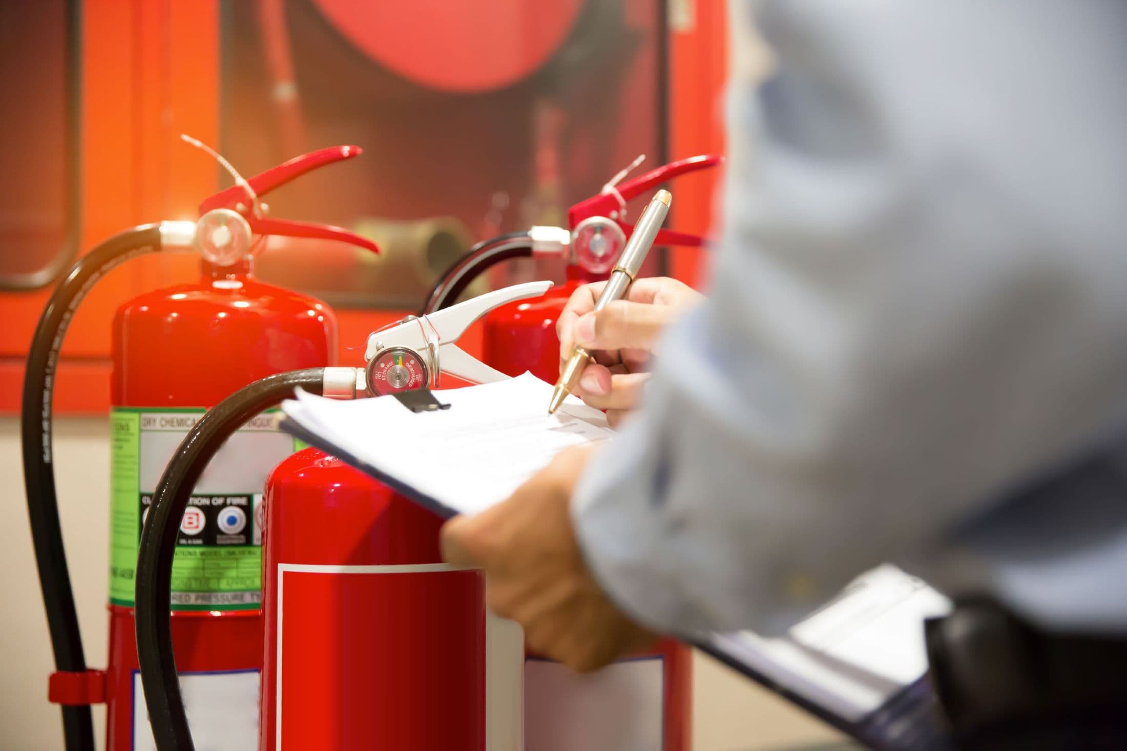 Fire safety inspection being recorded on a clipboard